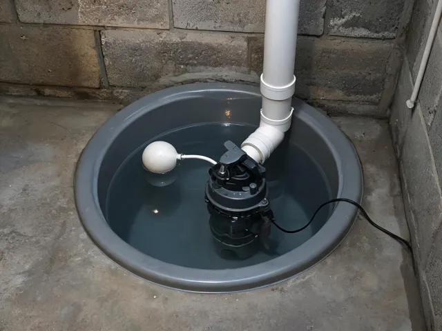 Sump pump basin with discharge line