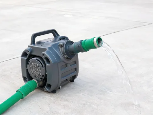 Utility pump transferring water through hose